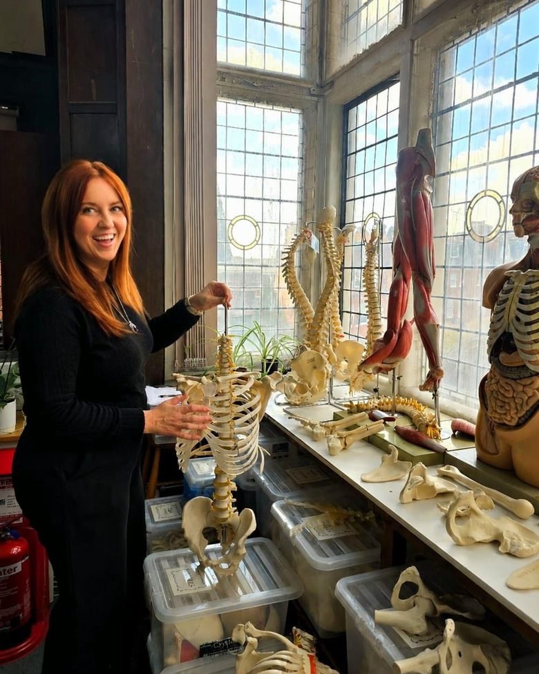 Gracie Jack, registered osteopath, with an anatomical spine model